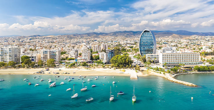 An aerial view of Limassol Cyprus showing the coastline, marina, and cityscape with a modern high-rise building